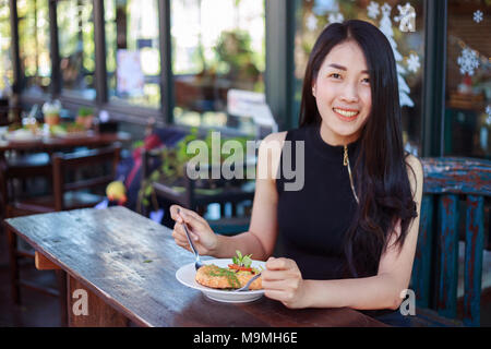 Junge Frau Essen in einem Restaurant Stockfoto