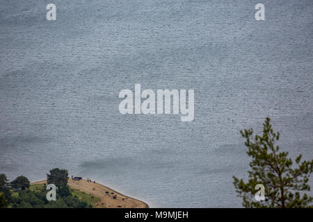 Blaue Wasser der Dospat Reservoir von hoch oben mit miniaturfiguren von Menschen angeln und eine Herde von Kühen in der Nähe von Ihnen Stockfoto