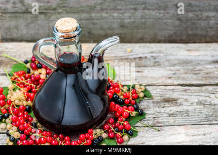 Obst Likör in einer Flasche, hausgemachten süßen Alkohol auf hölzernen Tisch Stockfoto