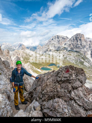 Wanderer auf der Klettersteig auf den Paternkofel, hinter Lago dei Piani mit Schusterplatte und Altensteinspitz, Sextner Dolomiten Stockfoto