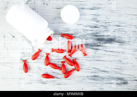 Omega-3-Fettsäuren in Fisch geprägt. Rote Kapseln von Fischöl in der Flasche auf weißem Hintergrund. Kopieren Sie Platz. Stockfoto