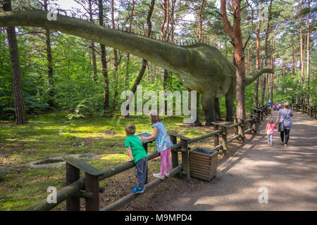 Solec Kujawski, Polen - August 2017: Kleine Kinder bei den massiven Replik der gigantischen Diplodocus Dinosaurier in einem Vergnügungspark auf der Suche Stockfoto