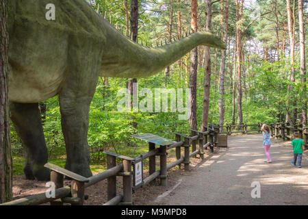 Solec Kujawski, Polen - August 2017: Kleine Kinder bei den massiven Replik der gigantischen Diplodocus Dinosaurier in einem Vergnügungspark auf der Suche Stockfoto