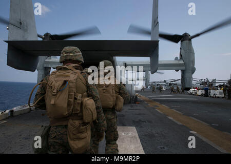 Marines mit Waffen Firma, Bataillon Landung Team, 1.BATAILLON, 1 Marines, 31 Marine Expeditionary Unit, Board eine MV-22 B Osprey Kipprotor-flugzeug für eine taktische Verwertung von Flugzeugen und Personal Training Szenario während an Bord der USS Wasp (LHD-1) im Ostchinesischen Meer, 26. März 2018. TRAP Schulung bereitet Marines taktisch Personal, Ausrüstung, oder Luftfahrzeuge durch Einlegen der Recovery Kraft zu ihren Speicherort wieder her. Wie das Marine Corps' nur kontinuierlich vorwärts - bereitgestellt MEU, den 31 MEU bietet eine flexible Kraft bereit, eine breite Palette von militärischen Operationen auszuführen. (U.S. Marin Stockfoto