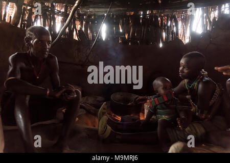 Familie sitzt in Lehmhütte, hamer Stamm, Turmi, Region der südlichen Nationen, Äthiopien Stockfoto