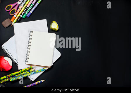 Sortierte bunte Schulmaterial auf schwarzem Hintergrund. Konzept mit kopieren. Stockfoto