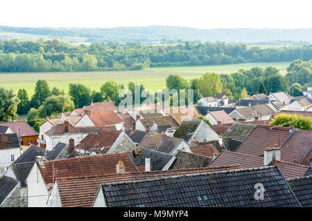 Dächer eines französischen Dorf mit einem grünen Hintergrund verblassen im Licht der untergehenden Sonne. Stockfoto