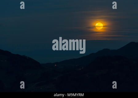 Super mond Vollmond golden in den Nachthimmel über ländliche alpine Landschaft in Bayern, Deutschland Stockfoto