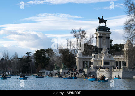 Touristen in Ruderboote auf dem See im Park Retiro, Madrid, Spanien, genießen perfektes Wetter Stockfoto