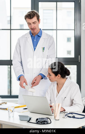 Arzt und Apotheker Prüfen von Informationen auf einem Laptop in ein modernes Krankenhaus Stockfoto