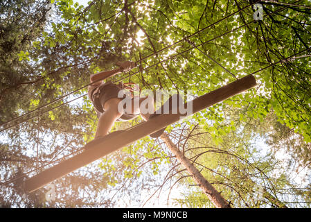 Teenager Spaß im Hochseilgarten, Abenteuer Park, Klettern Bäume in einem Wald im Sommer Stockfoto