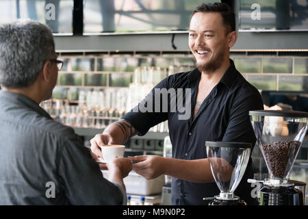 Barkeeper serviert Espresso mit einem Kunden Stockfoto