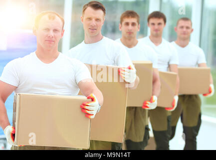 Team von Bauherren mit Boxen von Baustoffen Stockfoto