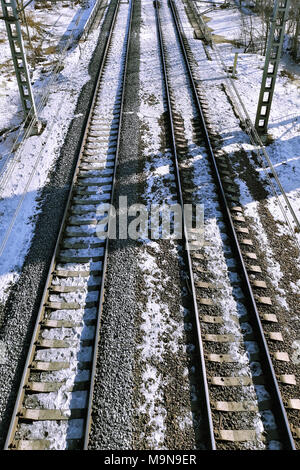 Bahn Damm mit Schienen in die Ferne gehen, an einem verschneiten März Tag. Stockfoto
