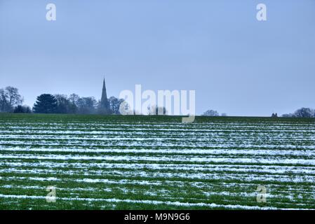 Englisch Land Kirche gesehen Über ausgefahrene Felder voller Schnee Stockfoto