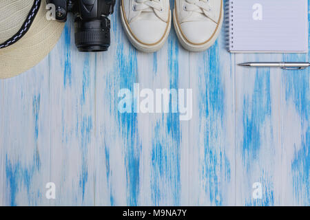 Topview von Reise Ausrüstung, Sonnenhut, Schuhe und Kamera auf Holz- Hintergrund. Kopieren Sie Raum für kreatives Design text und Wort. Stockfoto