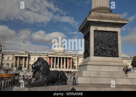 Touristische an der Basis der Nelson's Column auf Traflagar Platz gegenüber der National Gallery in London. Stockfoto