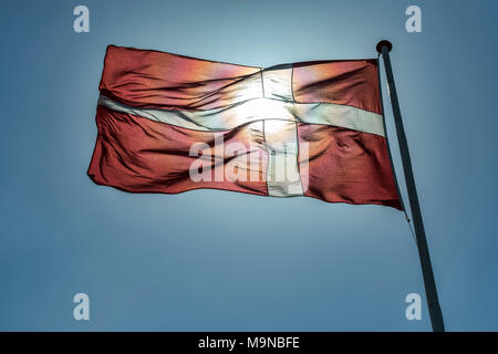 Die dänische Flagge mit der Sonne thru Stockfoto