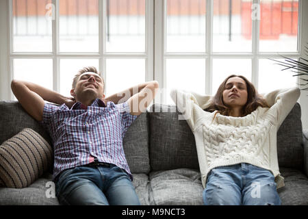 Entspannt Mann und Frau genießen Entspannung oder in nap zu Hause auf der bequemen Couch, glückliches junges Paar frische Luft meditieren lehnte sich auf Sof Stockfoto