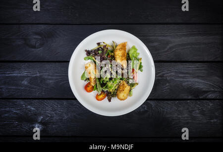 Salat mit Lachs in Blätterteig mit Salat und Sesam. Stockfoto