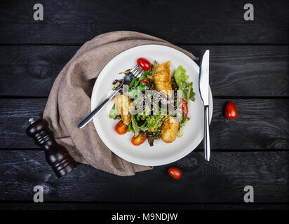 Salat mit Lachs in Blätterteig mit Salat und Sesam. Stockfoto