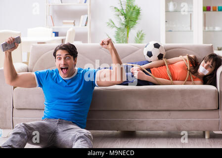 Mann binden bis seine Frau zur sportschau Fußball Stockfoto