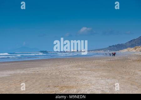 Wanderer Position am Strand entlang in Richtung Tywyn, Gwynedd, Wales Stockfoto