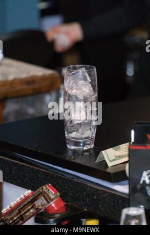 Hohen Felsen Glas gefüllt mit Eis sitzt auf Restaurant bar Zähler nach oben vor dem Barkeeper gießen Alkohol gemischt Trinken für Kundenauftrag Stockfoto