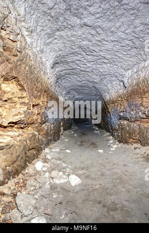 Die alte Sandstein Tunnel, Höhlen abgebaut. Die Höhle. Sandstein Tunnel feuchten Wänden. Trockene Kanal in den felsigen Untergrund geschnitzt Stockfoto