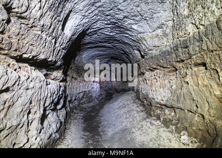 Die alte Sandstein Tunnel, Höhlen abgebaut. Die Höhle. Sandstein Tunnel feuchten Wänden. Trockene Kanal in den felsigen Untergrund geschnitzt Stockfoto