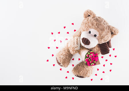 Ansicht von oben Teddybär mit Blumenstrauß aus Rosen isoliert auf weißem, Valentines Tag Konzept Stockfoto