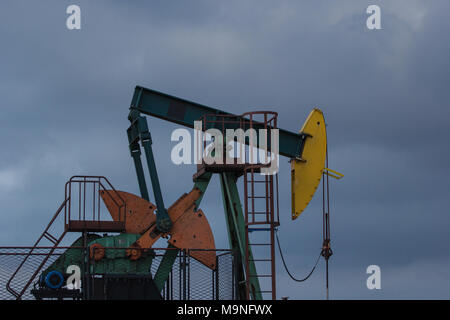 Ein Öl pumpe im Đeletovci, Kroatien. Sonnenuntergang im Hintergrund. Eine pumpjack ist der oberirdische Antrieb für ein hubkolben Pumpe in einem Öl wel Stockfoto