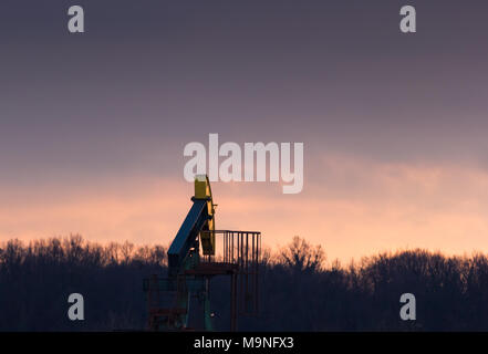 Ein Öl pumpe im Đeletovci, Kroatien. Sonnenuntergang im Hintergrund. Eine pumpjack ist der oberirdische Antrieb für ein hubkolben Pumpe in einem Öl wel Stockfoto