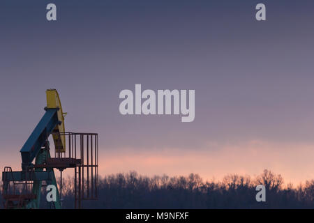 Ein Öl pumpe im Đeletovci, Kroatien. Sonnenuntergang im Hintergrund. Eine pumpjack ist der oberirdische Antrieb für ein hubkolben Pumpe in einem Öl wel Stockfoto