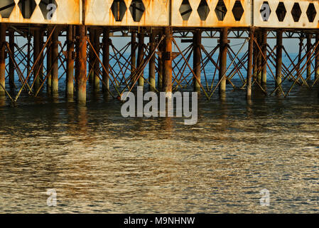 Blick entlang der Unterseite des Portsmouths South Parade Pier in Fareham, England, Seite beleuchtet auf ein ruhiger Tag, Stahlträger und Säulen Stockfoto