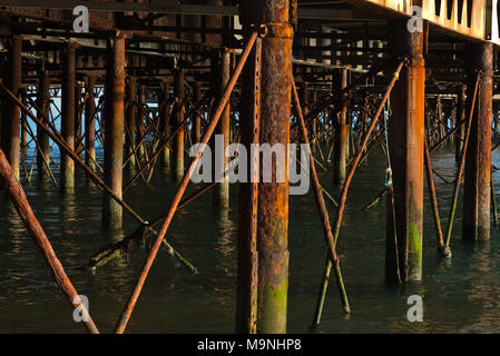 Blick entlang der Unterseite des Portsmouths South Parade Pier in Fareham, England, Seite beleuchtet auf ein ruhiger Tag, Stahlträger und Säulen Stockfoto