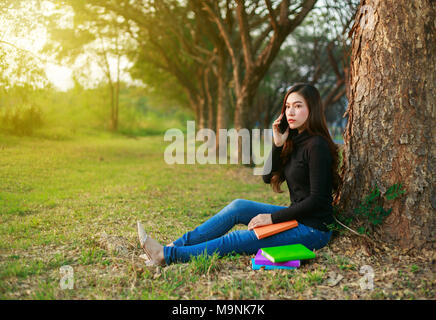 Frau Gespräch am Handy im Park Stockfoto