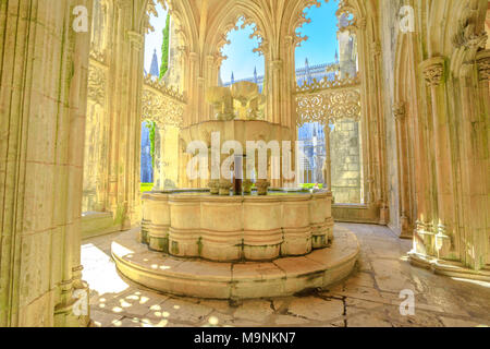 Batalha, Portugal - 16. August 2017: Glühen, das Filter durch die Arkaden rund um die Toilette oder die berühmten Brunnen von Mateus Fernandes im Kloster von Batalha, Unesco Welterbe in Portugal. Stockfoto