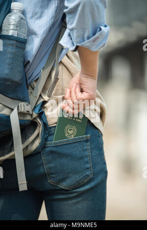 Die Reisenden nehmen ihre koreanischen Pässe aus ihren Jeans Gesäßtaschen. Stockfoto