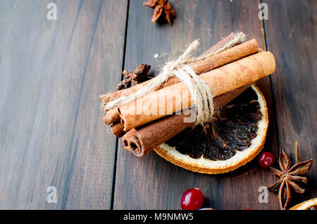 Sticks Zimt, Anis, Gewürze für Tee und getrocknete kandierte Früchte auf dunklem Hintergrund, Stockfoto