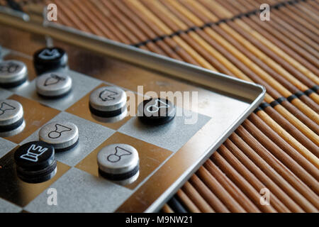 Foto mit einem Bild von einem Schach Stahl- und Schachfiguren, Metall Schachfiguren auf einem Schachbrett mit Reflektion Stockfoto