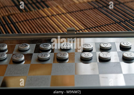Foto mit einem Bild von einem Schach Stahl- und Schachfiguren, Metall Schachfiguren auf einem Schachbrett mit Reflektion Stockfoto
