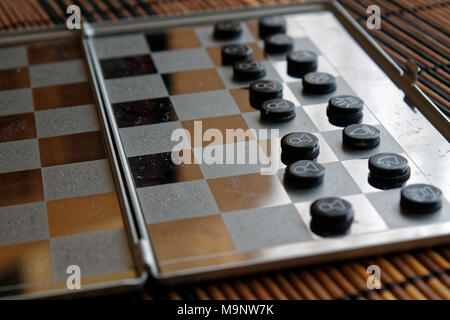 Foto mit einem Bild von einem Schach Stahl- und Schachfiguren, Metall Schachfiguren auf einem Schachbrett mit Reflektion Stockfoto