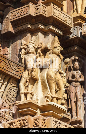 Alte Schnitzereien von Zahlen auf einen hinduistischen Tempel in der Gruppe West der Khajuraho Gruppe von Denkmälern in Khajuraho, Madhya Pradesh, Indien Stockfoto