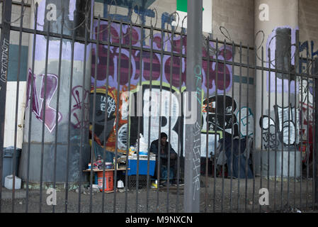 LOS ANGELES, Ca - 15. März 2018: Unbekannter Obdachlosen sitzen auf dem Bürgersteig unter der Brücke in der Innenstadt von Los Angeles am 15. März 2018, Stockfoto