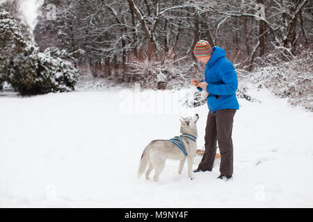 Mann mit Husky Hund im Winter Stockfoto