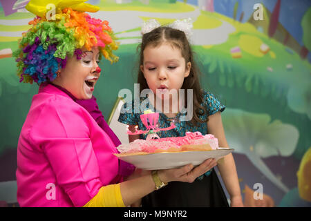 Belarus, Gomel, November 9, 2017. Gomel Children's Center. Um einen Geburtstag zu feiern. Die Kerzen ausblasen auf eine festliche Kuchen. Der Clown hat den Kuchen Stockfoto