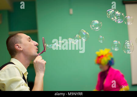 Belarus, Gomel, November 9, 2017. Gomel Children's Center. Kinder- Urlaub. Ein Mann bläst Seifenblasen. Die Seifenblase Aufpumpen Stockfoto