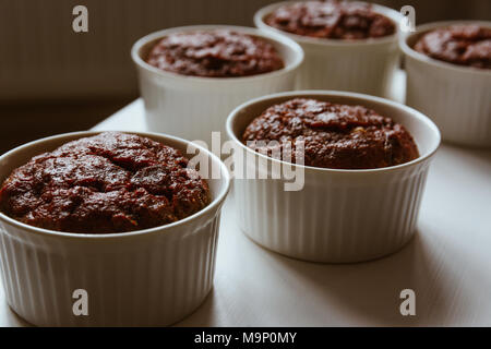 Gesund vegan Rote Bete Muffins in weißen Tassen auf weißer Tisch. Festliche Komposition, geringe Tiefenschärfe. Film Effekt. Stockfoto