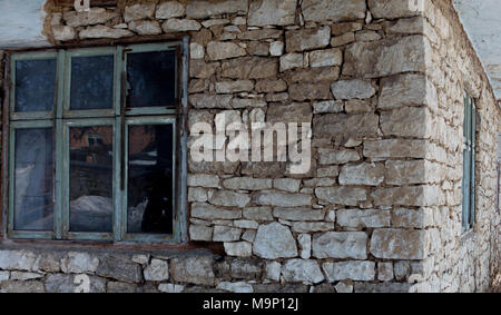 Das Fenster in der alten Mauer aus Stein Weiß isoliert. Stockfoto